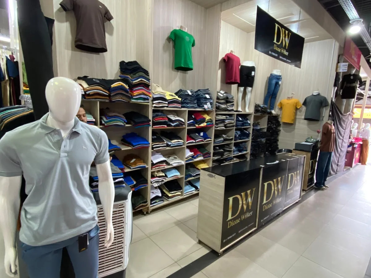 Interior da loja DW Mens Wear no Shopping Centro Oeste Express, com camisetas e calças expostas
