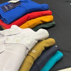 Camisas gola polo em piquê empilhadas em várias cores
